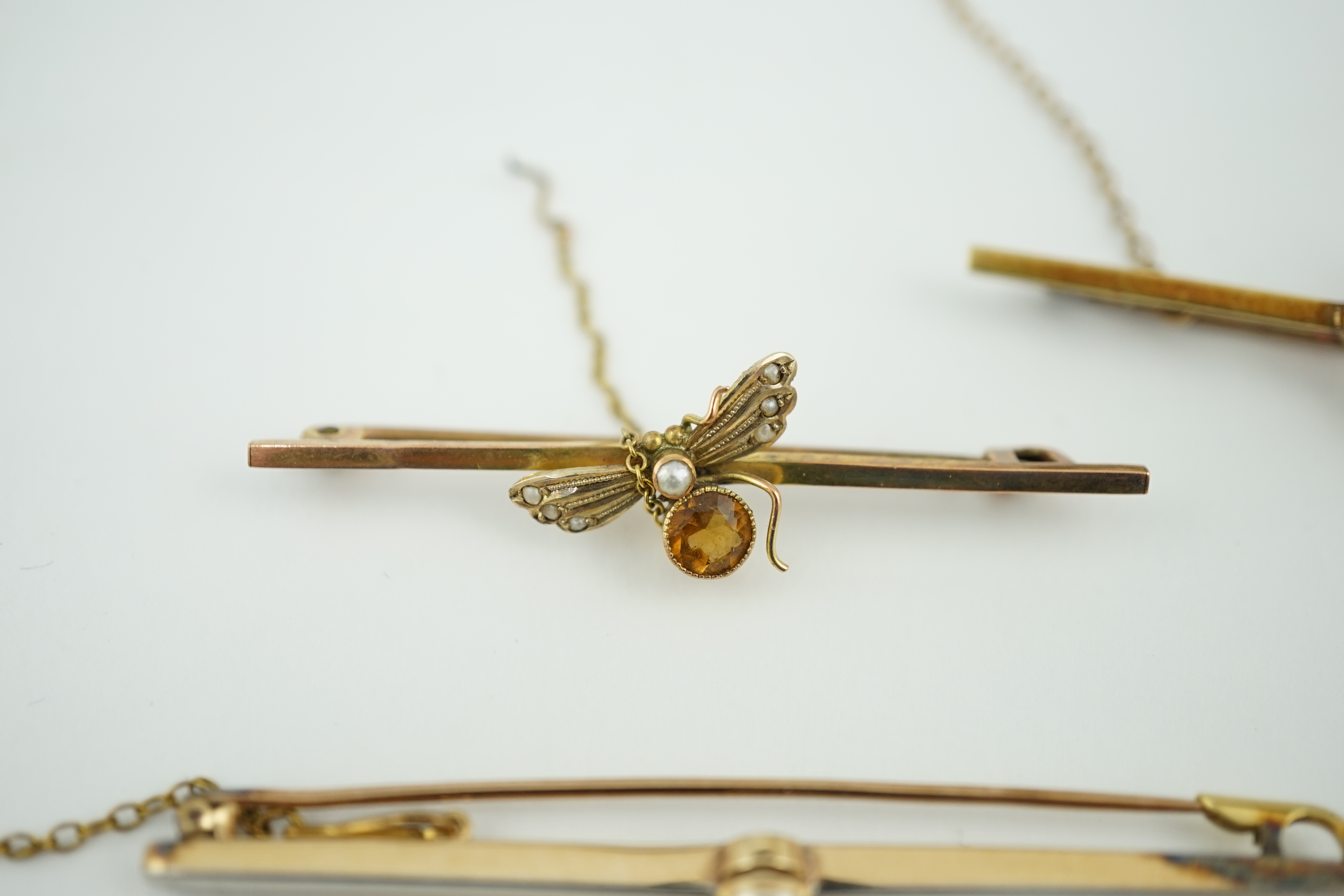 Five assorted Edwardian bar brooches, including a 15ct gold sapphire and diamond set three stone, a diamond and seed pearl, ruby? and seed pearl, a solitaire diamond set and a seed pearl and citrine bug brooch